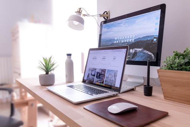 view of a desktop and laptop in a personal sunny office